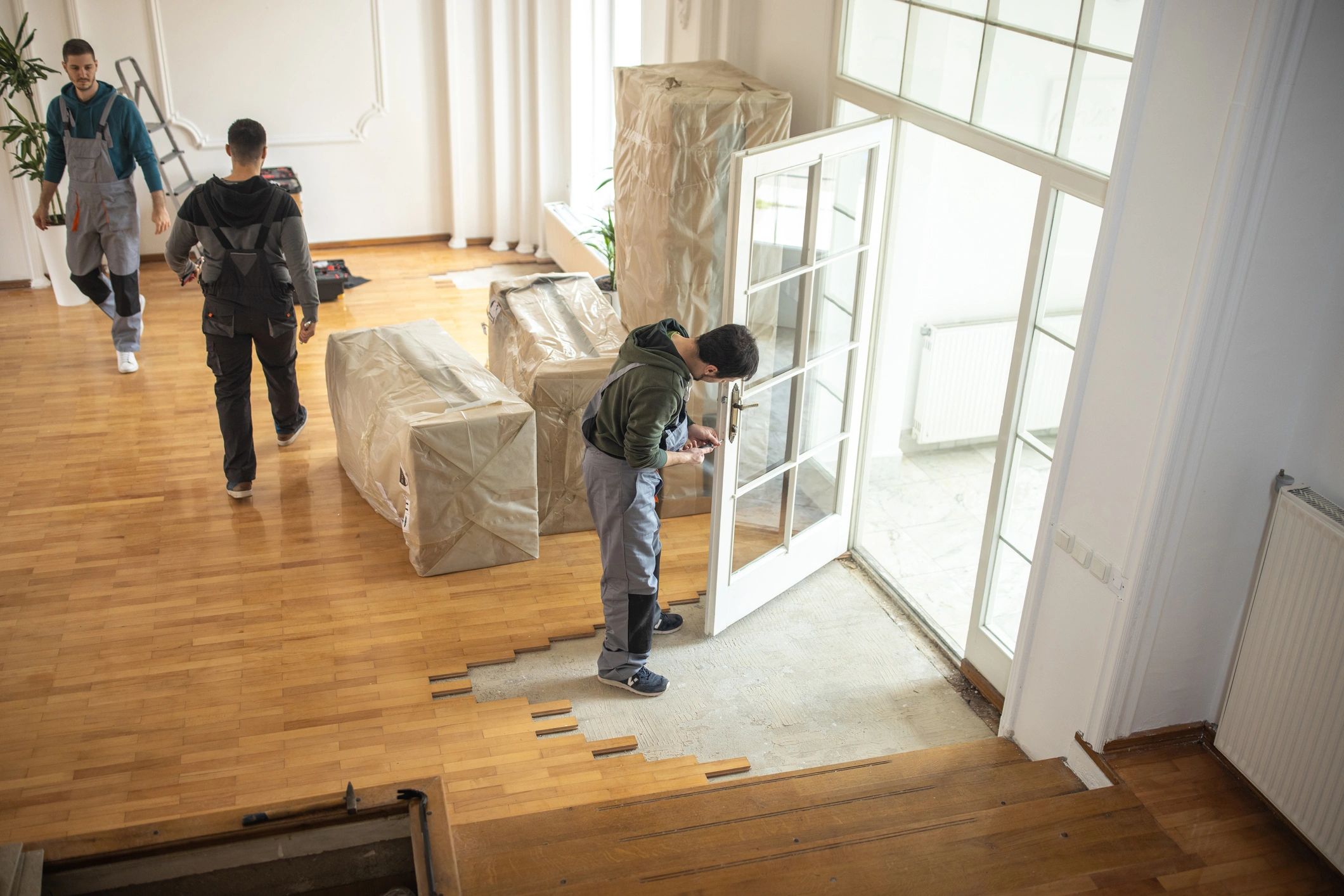 Workers performing hands-on cleanup and hauling work inside a property